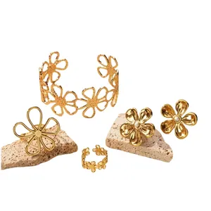 Elegant gold hollow flower jewelry set with daisy ring, earrings, and cuff bracelet