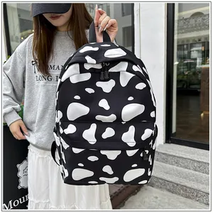 Stylish casual student backpack featuring bold black and white cow print pattern