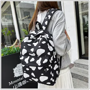 Detailed view of casual cow-print backpack worn by a student in an outdoor setting