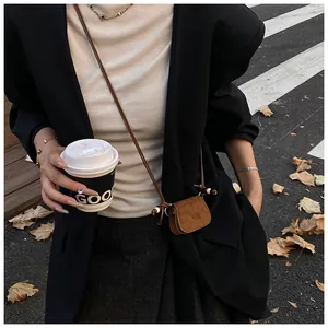 Detailed view of a vintage brown suede mini crossbody coin purse for autumn fashion