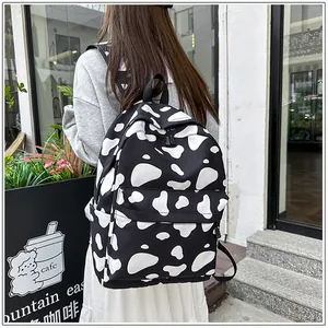Detailed view of stylish black and white cow print backpack for casual school use