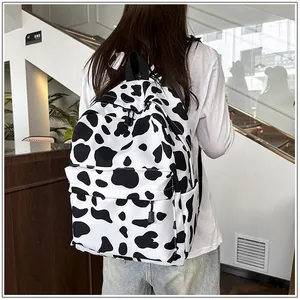 Detail shot of a casual cow print backpack worn by a student in a modern cafe