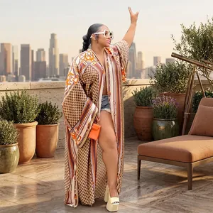 Full body front view of a loose printed long kimono coat styled with denim shorts