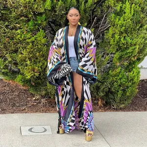 Full view of women's colorful geometric print kimono cardigan in a lush garden setting