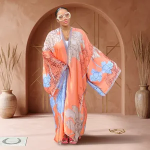 Elegant orange long kimono robe with light blue floral print in outdoor garden setting