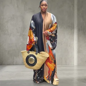 Model in a loose long-sleeved printed kimono maxi dress posed in a scenic garden setting.