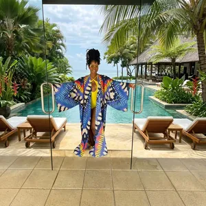 Vibrant bohemian patterned long kimono cover-up displayed in a stylish resort doorway setting