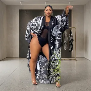 Full-body view of a plus-size model wearing a black and white printed kimono cardigan.