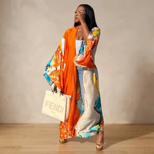 A full-length view of a vibrant orange floral print loose long kimono duster coat