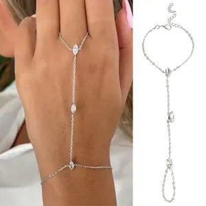 Detailed view of a silver-toned hand chain bracelet with marquise rhinestones on a hand.