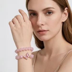 Detail shot of elegant pink natural crystal bracelet set with butterfly charm on wrist