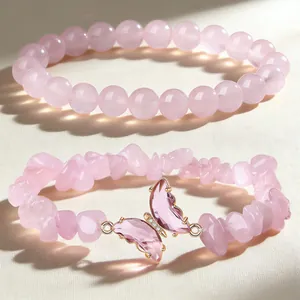 Macro view of natural rose quartz bead bracelet set featuring a pink butterfly charm