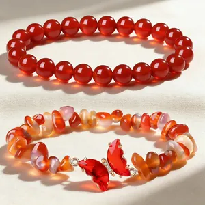 Detail of red agate bracelet set with 8mm round beads and butterfly stone charm.