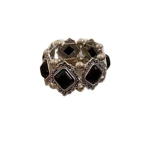 Elegant vintage silver-toned bracelet with ornate engraved frames and black rhombus stones
