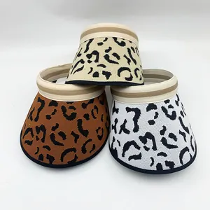Detailed macro view of leopard print knitted sun visors in beige, brown, and white.