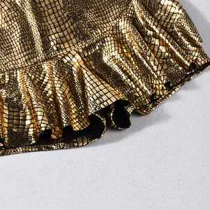 Close-up macro shot of gold metallic crocodile embossed fabric with ruffled hemline