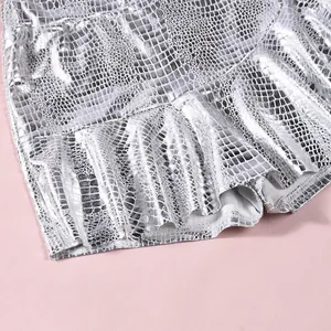 Detailed view of silver metallic faux leather skirt featuring embossed snake skin texture