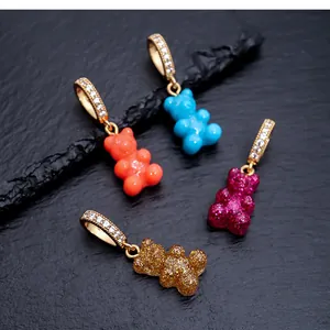 Detailed macro shot of four colorful gummy bear drop earrings with sparkly CZ gold hoops.