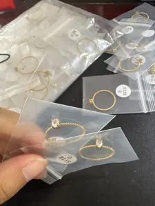 Detailed shot of gold-plated twisted rings with oval zircons in clear polybags