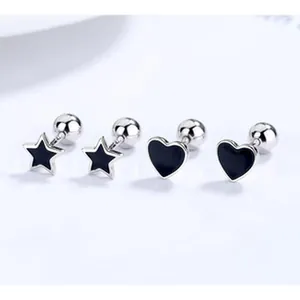 Close-up of minimalist 925 sterling silver heart and star screw-back stud earrings