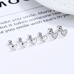 Close-up detail of three pairs of silver heart-shaped screw back stud earrings.