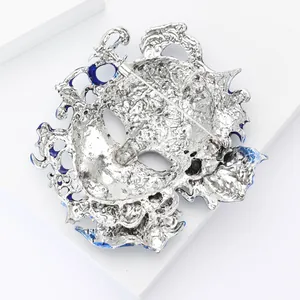 Detailed macro view showing the sturdy back pin of an ornate silver alloy mask brooch
