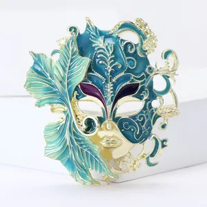 Close-up detail of an ornate teal and gold enamel carnival mask brooch accessory