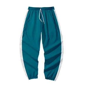 Détail du jogging de sport vert foncé pour enfants avec larges rayures latérales
