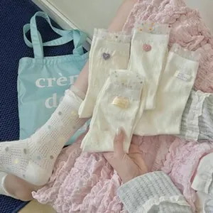 Creamy white mid-tube cotton socks featuring cute heart accents and lace trim edges