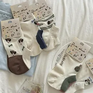 Detailed view of women's cotton ankle socks with cute cartoon dog patterns and colors.