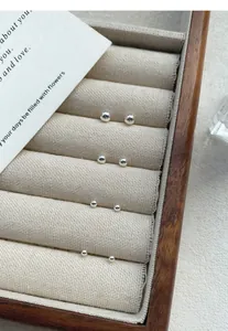 Close-up of minimalist S999 sterling silver round ball stud earrings in jewelry tray