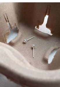 Close-up of S999 sterling silver smooth round bead stud earrings in rustic setting