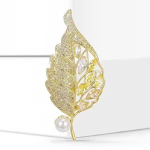 Close-up detail of a high-end gold leaf brooch featuring micro-set yellow zircons