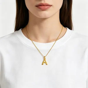 Gold initial A necklace with textured bamboo finish on model in white tee