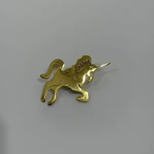 Gros plan détaillé d'une broche licorne en acier inoxydable doré au fini brillant