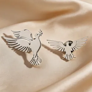 Detailed macro view of silver stainless steel bird brooches on luxury satin fabric