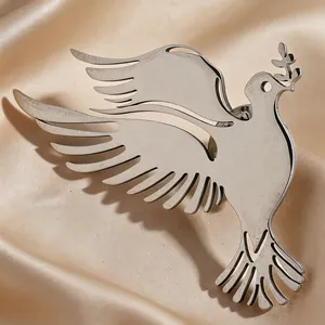 Macro detailed shot of a minimalist stainless steel peace dove bird brooch on silk fabric