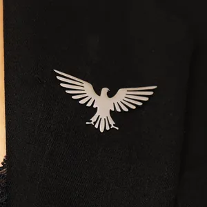 Elegant silver stainless steel bird brooch in eagle shape pinned on black suit jacket