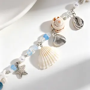 Nahaufnahme einer böhmischen Meereshalskette mit Perlen, Muscheln und Seesternen.