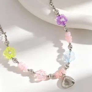 Detailaufnahme einer böhmischen Strandkette mit bunten Blumen und einem Muschelanhänger.
