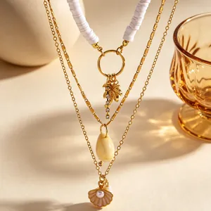 Dettaglio ravvicinato di collana a strati stile oceano con palma e ciondoli a conchiglia