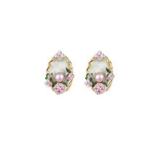 Elegant enamel flower stud earrings with pink pearls and gold accents on white background
