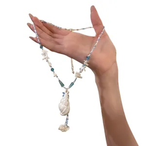 Blue starfish and conch beaded necklace for summer beach style, shown held by a hand.