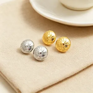 Detailansicht von gold- und silberfarbenen Edelstahl-Ohrsteckern mit Spiralstruktur.