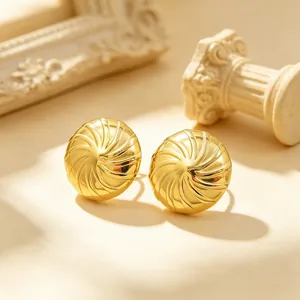 Nahaufnahme von luxuriösen goldenen spiralförmigen Edelstahl-Ohrsteckern mit Struktur