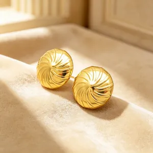 Nahaufnahme von goldfarbenen Edelstahl-Ohrsteckern mit elegantem Spiralmuster