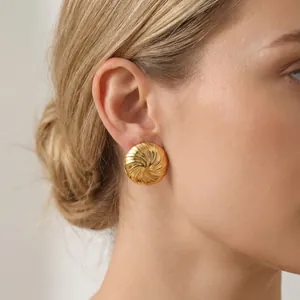 Detailansicht eines Models mit einem luxuriösen goldenen Spiral-Ohrstecker aus Edelstahl.
