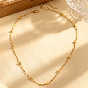 Minimalistische goldene Perlenkette in einem eleganten Lifestyle-Ambiente mit weichen Schatten