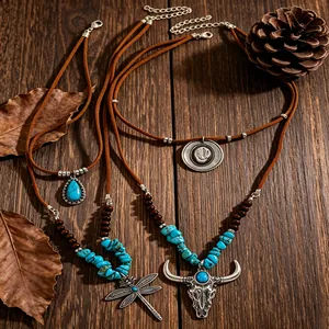 Gedetailleerd aanzicht van western turquoise kettingset met stierenkop en libel hangers.