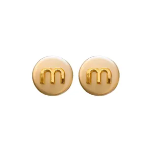 Elegant silver needle round stud earrings with golden letter m detail in cream